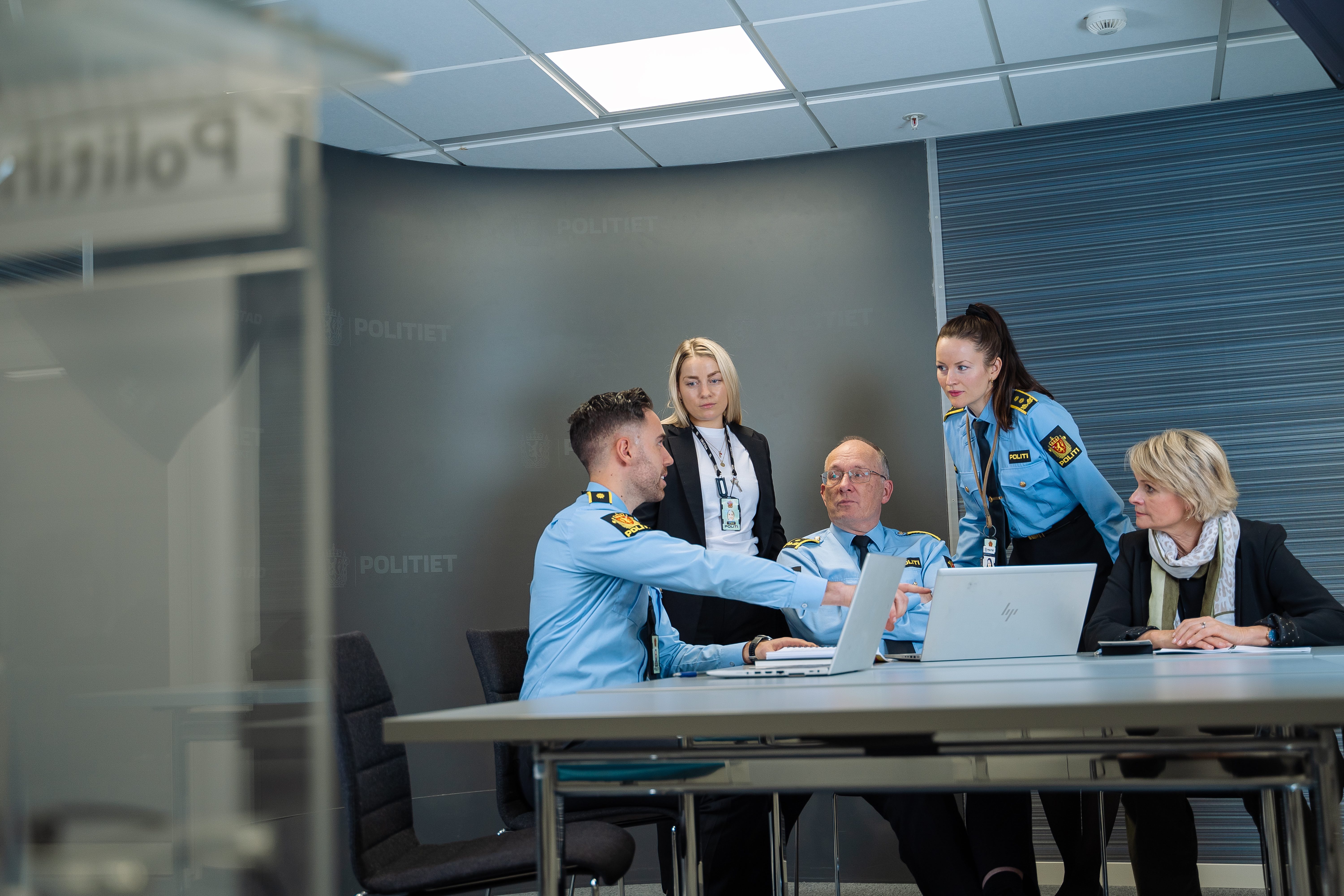 Kollegaer i politiet som snakker sammen på et kontor. Foto.