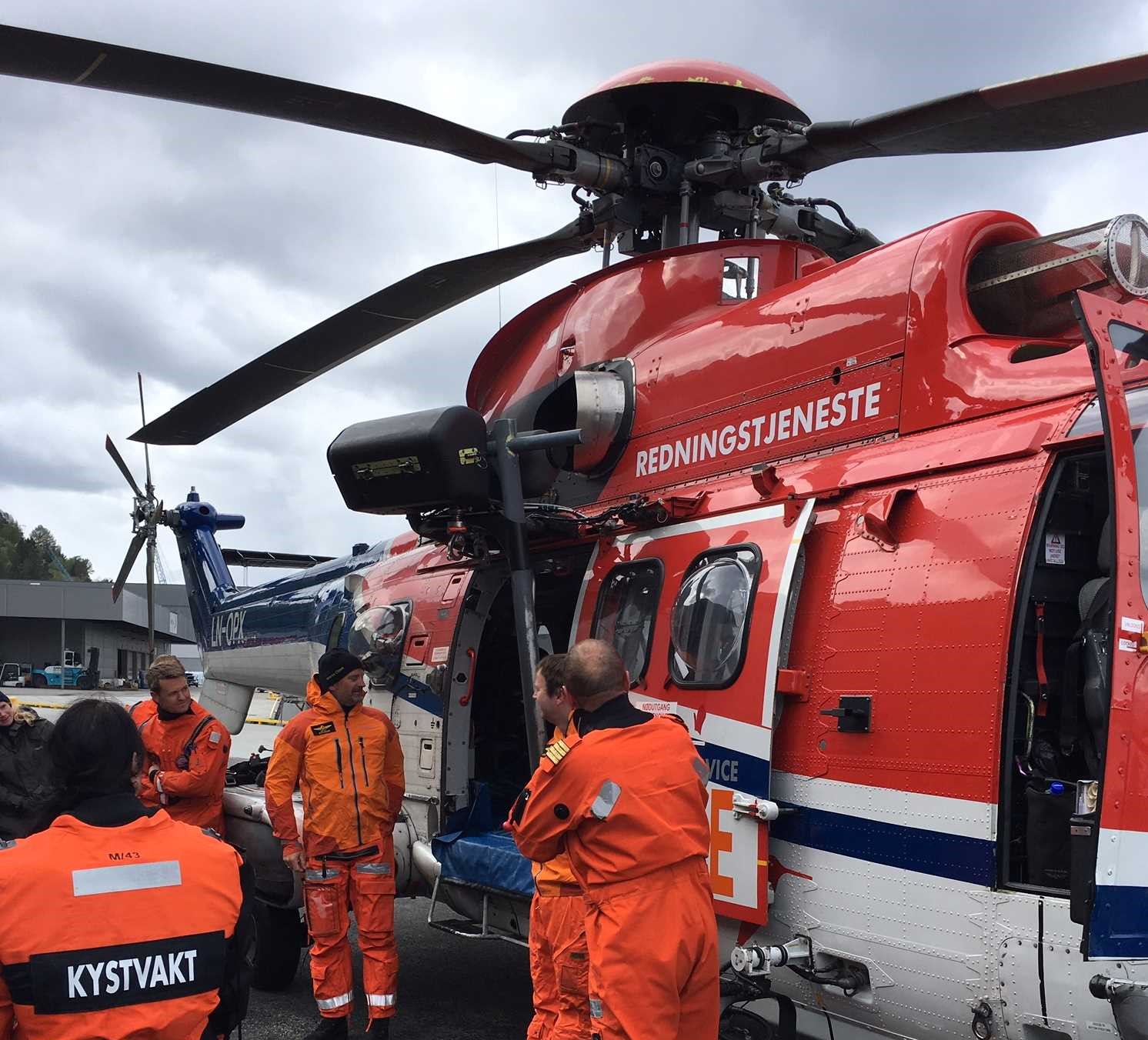 Fartøysjefen gir en orientering utenfor helikopteret. Foto