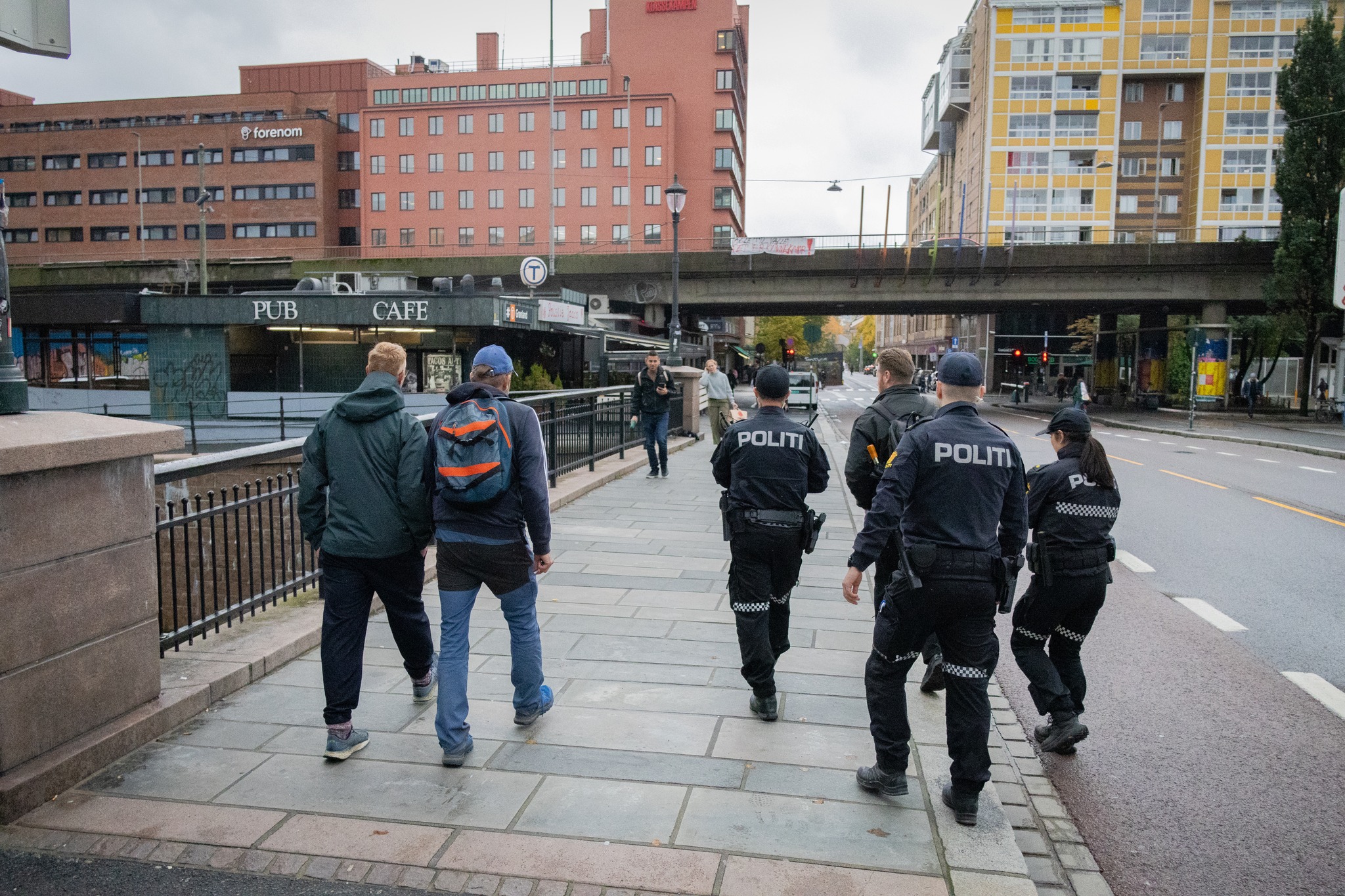 Bildet viser tre sivile og tre politifolk i gatene som man ser ryggen til.