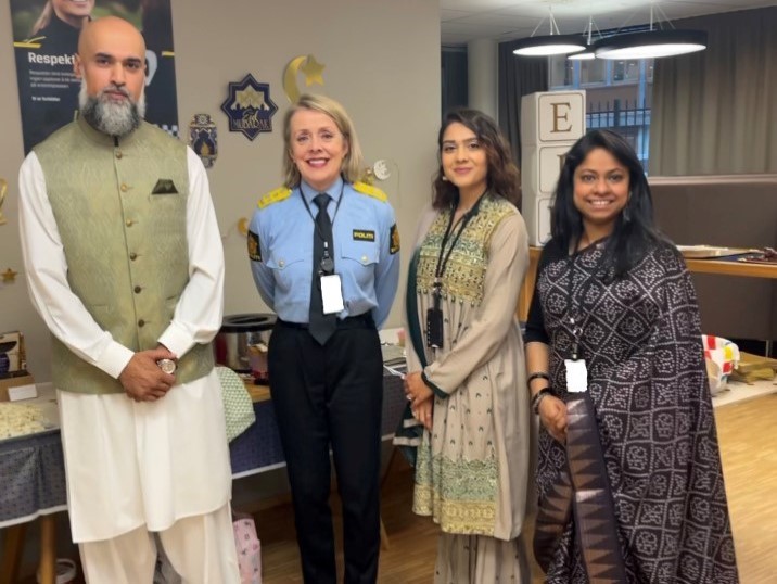 Masood Fazal, politidirektør Benedicte Bjørnland, Asifa Malik og Sharmin Ahmed foran et bord fylt med mat.