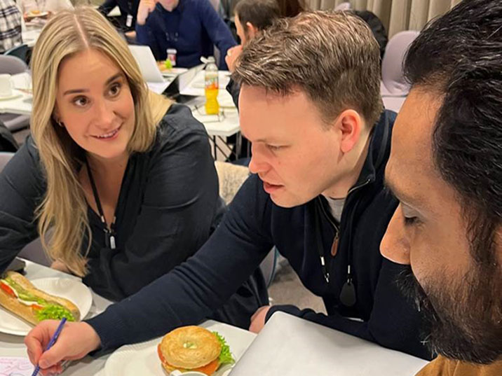 Heidi, Knut og Amandeep sitter rundt et bord og tegner en kunnskapsgraf.